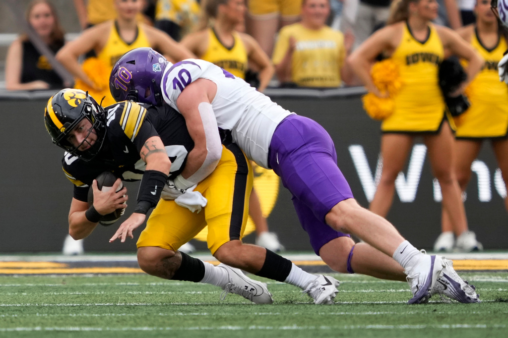 Iowa quarterback Jeremy Hecklinski, left, is sacked by Northern Iowa linebacker Kolben Miller during the first half of an NCAA college football game in Iowa City, Iowa, Saturday, Sept. 19, 2026. (AP Photo/Charlie Neibergall)