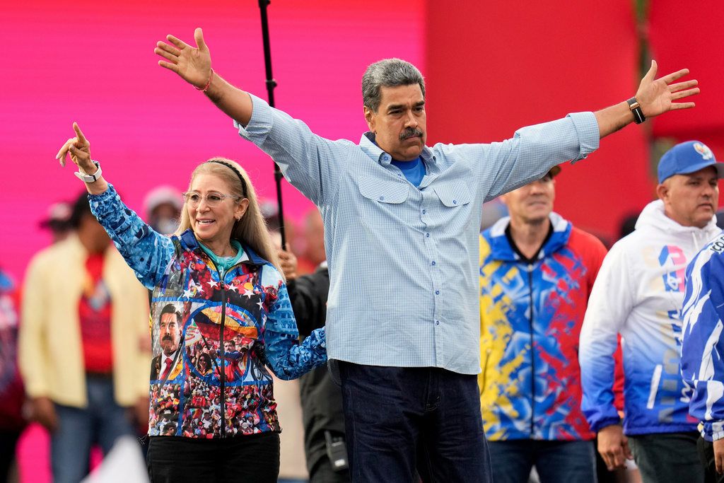 FILE - President Nicolas Maduro acknowledges supporters alongside first lady Cilia Flores during his closing election campaign rally in Caracas, Venezuela, July 25, 2024. (AP Photo/Fernando Vergara, File)