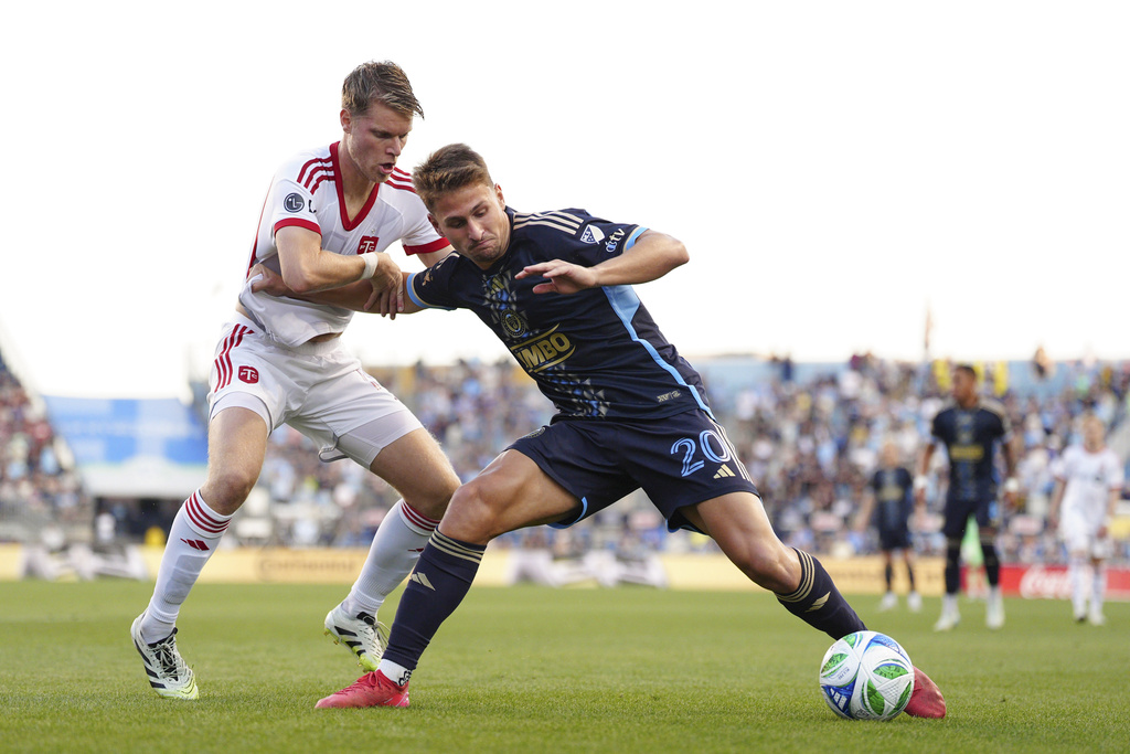Philadelphia Union's Bruno Damiani, right, and Toronto FC's Sigurd Rosted, left, battle for position during the first half of an MLS soccer match, Saturday, Aug. 9, 2025, in Chester, Pa. (AP Photo/Derik Hamilton)