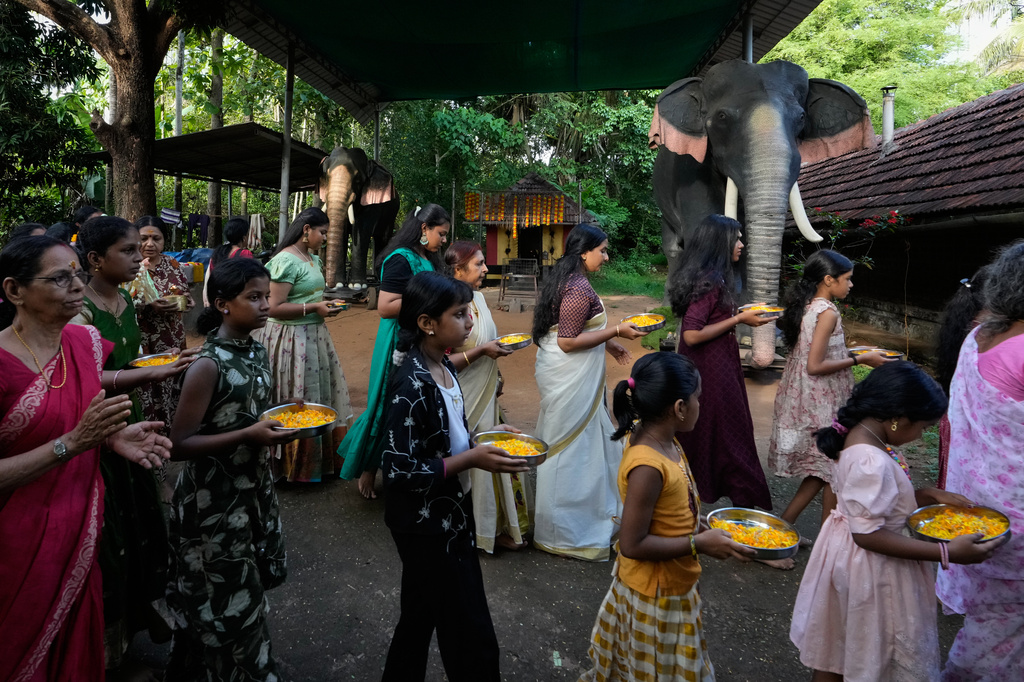 A group of Hindu devotees arrive for prayers, walking past two robotic elephants at Irinjadapilly Sree Krishna Temple in Thrissur, in the southern Indian state of Kerala, Friday, May 22, 2026. (AP Photo/Aijaz Rahi)