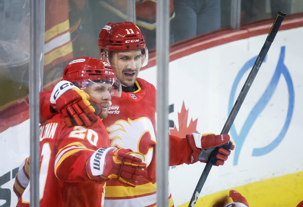 Calgary Flames' Blake Coleman, left, celebrates after his goal with teammate Mikael Backlund, right, during third-period NHL hockey game action against the New York Rangers in Calgary, Alberta, Sunday, Oct. 26, 2025. (Jeff McIntosh/The Canadian Press via AP)