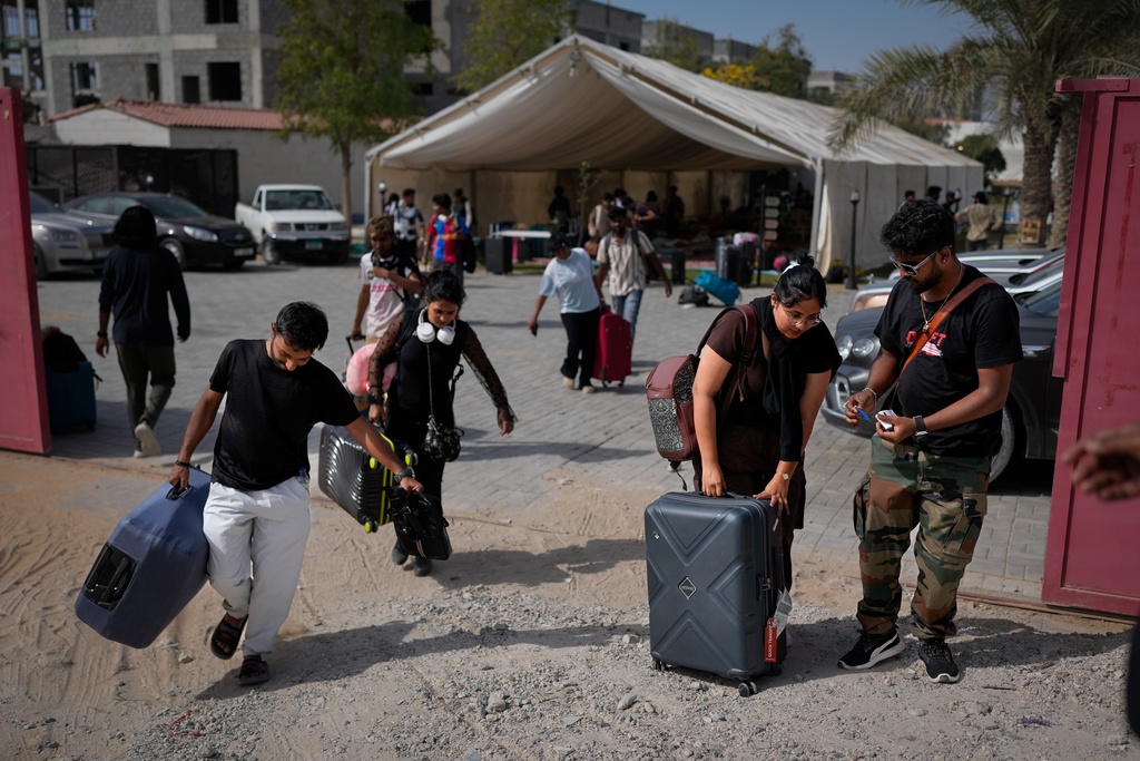 Stranded foreign travelers depart the farmhouse owned by an Indian businessman, now converted into a shelter, in Ajman, near Dubai, United Arab Emirates, Saturday, March 7, 2026. (AP Photo/Altaf Qadri)