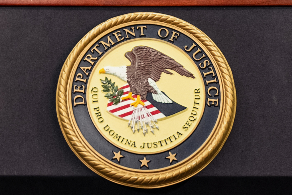 FILE - The Department of Justice logo is seen on a podium during a press conference at the U.S. Attorney's Office, Oct. 23, 2025, in New York. (AP Photo/Angelina Katsanis, File)