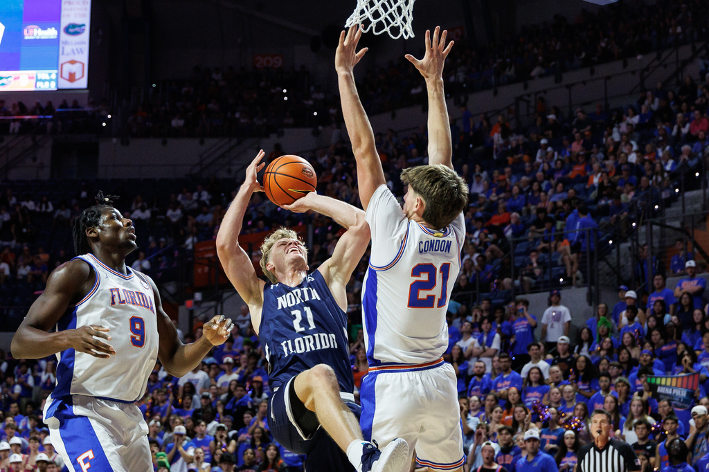 Florida forward Alex Condon, right, blocks North Florida guard Dalton Gayman, second from right, during the first half of an NCAA college basketball game Thursday, Nov. 6, 2025, in Gainesville, Fla. (AP Photo/Chris Watkins)