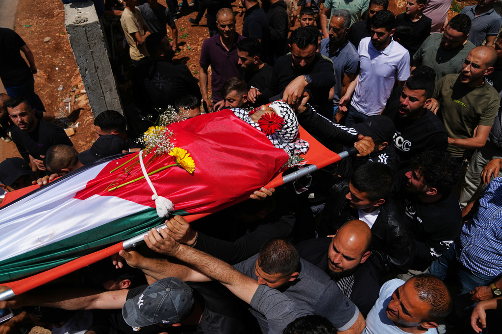 Mourners carry the body of Palestinian Zakaria Qatousa, during his funeral in the West Bank town of Deir Qaddis Wednesday, May 13, 2026. (AP Photo/Mahmoud Illean)