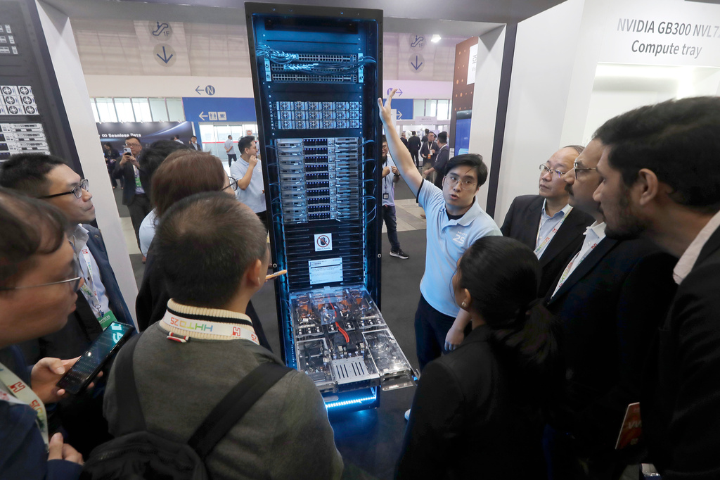 Visitors listen to the introduction of NVIDIA GB300 NVL72 AI server during the Hon Hai Tech Day (HHTD 25) at the Nangang Exhibition Center in Taipei, Taiwan, Friday, Nov. 21, 2025. (AP Photo/Chiang Ying-ying)