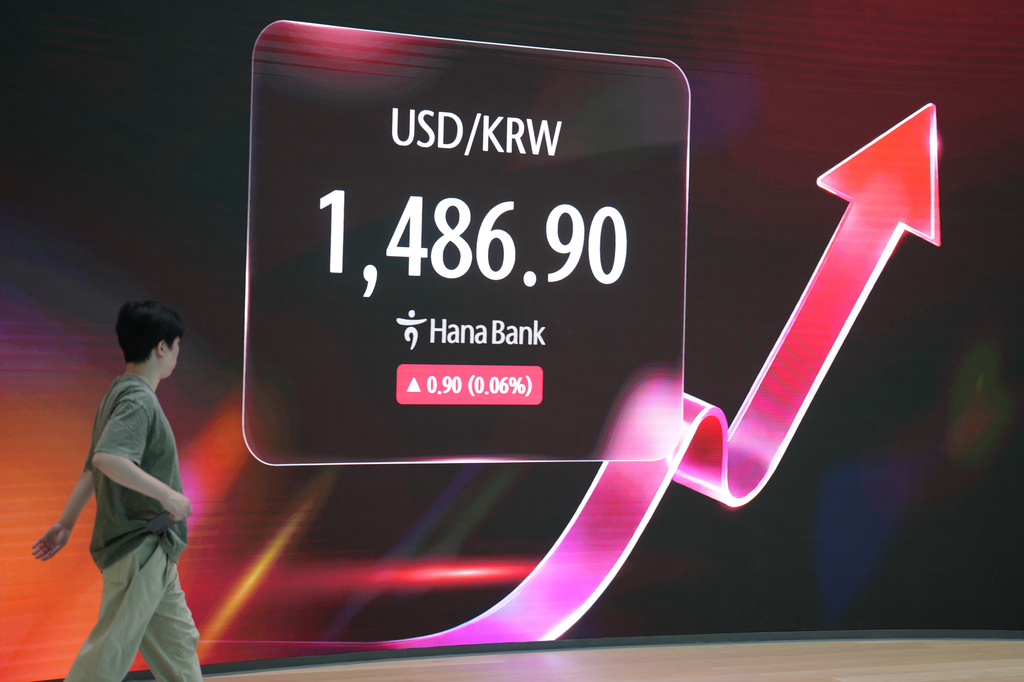 An employee walks past near the screen showing the foreign exchange rate between U.S. dollar and South Korean won at a dealing room of Hana Bank in Seoul, South Korea, Monday, July 20, 2026. (AP Photo/Lee Jin-man)
