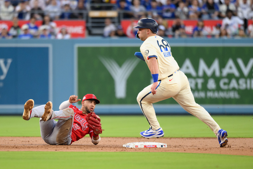 Los Angeles Dodgers' Dalton Rushing, right, rounds second base past Los Angeles Angels second baseman Oswald Peraza during the first inning of a baseball game in Los Angeles, Saturday, June 6, 2026. (AP Photo/Kyusung Gong)