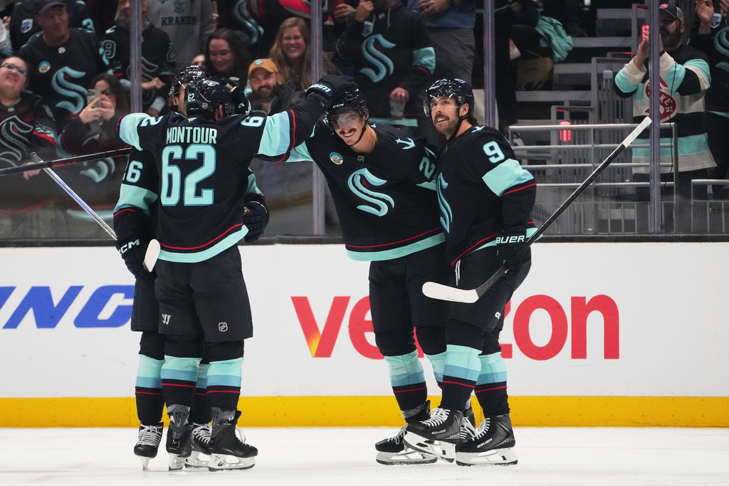 Seattle Kraken left wing Mason Marchment, second from right, celebrates his goal against the Anaheim Ducks with teammates, including center Chandler Stephenson (9), defenseman Brandon Montour (62) and center Ryan Winterton (26) during the second period of an NHL hockey game Thursday, Oct. 9, 2025, in Seattle. (AP Photo/Lindsey Wasson)