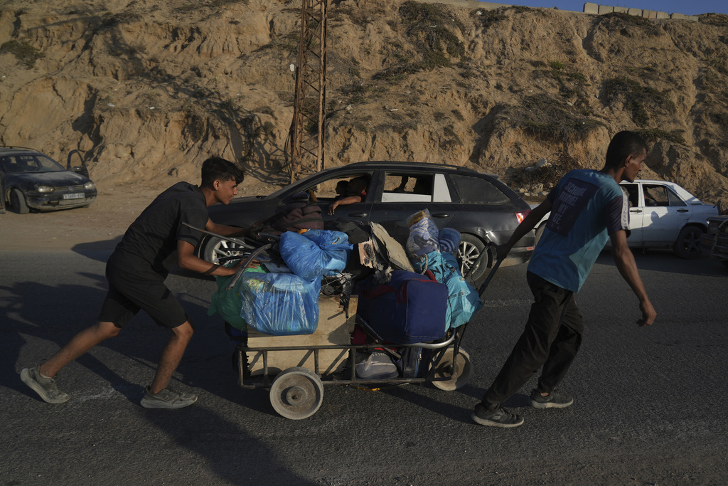 Displaced Palestinians fleeing northern Gaza Strip move with their belongings along the Sea Road, near Wadi Gaza, Saturday, Aug. 30, 2025. (AP Photo/Abdel Kareem Hana)