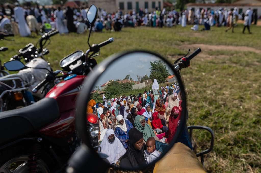 Muslims are reflected in a motorcycle mirror as they gather to pray at Sayo Muhamed School during the Eid al-Adha celebration amid an Ebola outbreak in Bunia, Congo, Wednesday, May 27, 2026. (AP Photo/Moses Sawasawa)