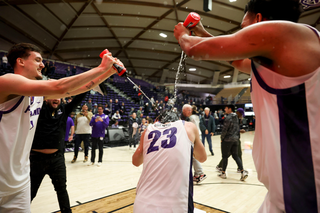 Portland forward Matus Hronsky, left, and center Jermaine Ballisager Webb, right, spray guard Joel Foxwell, center, with water following their team's win over Gonzaga in an NCAA college basketball game in Portland, Ore., Wednesday, Feb. 4, 2026. (AP Photo/Amanda Loman)