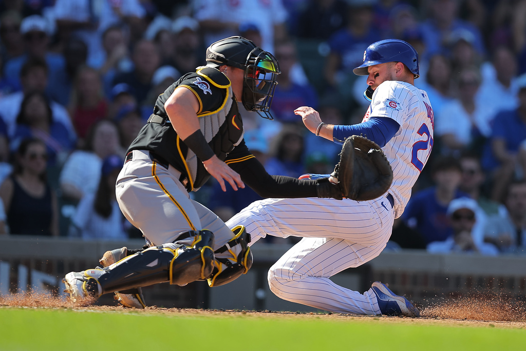 Chicago Cubs' Michael Busch scores past Pittsburgh Pirates catcher Henry Davis during the sixth inning of a baseball game, Friday, Sept. 11, 2026, in Chicago. (AP Photo/Melissa Tamez)