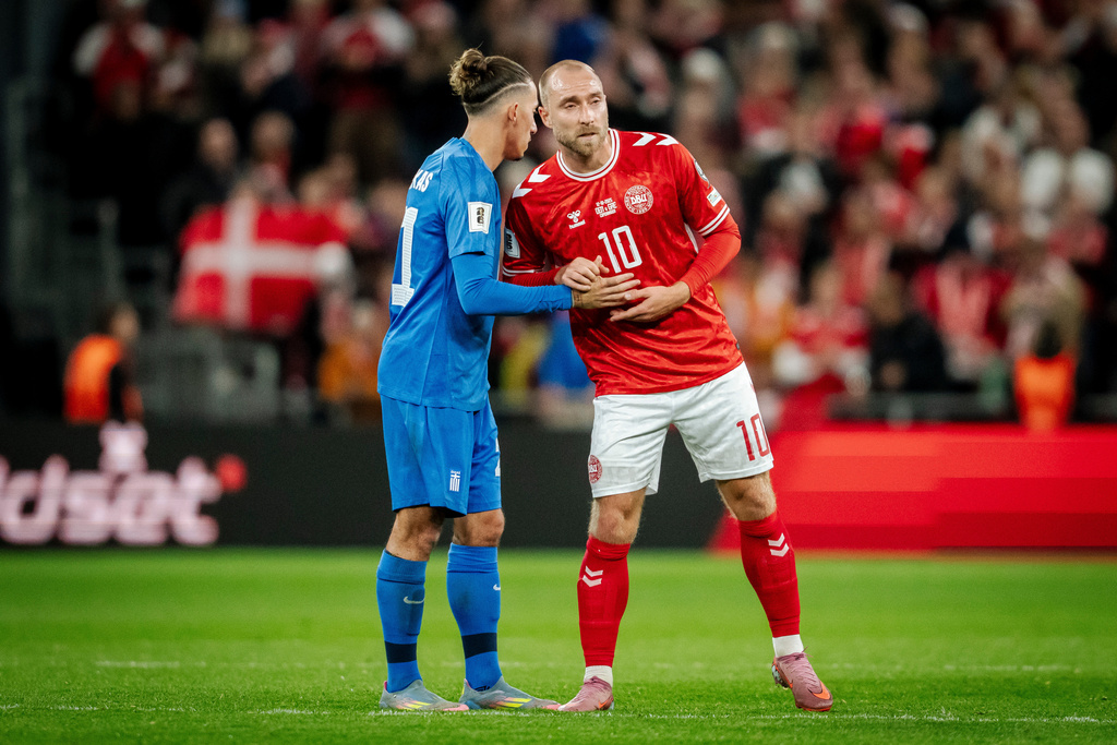 Greece's Kostas Tsimikas, left, and Denmark's Christian Eriksen, right, meet after the World Cup Group C qualification match between Denmark and Greece at Parken stadium in Copenhagen, Sunday, Oct. 12, 2025. (Mads Claus Rasmussen/Ritzau Scanpix via AP)