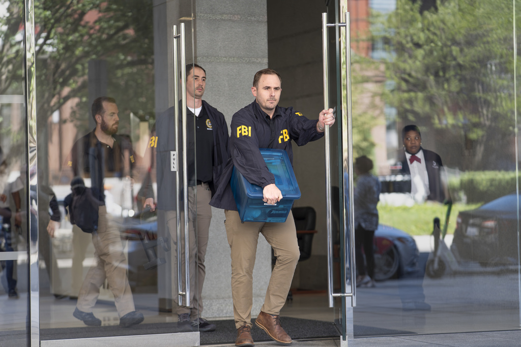 FBI agents depart the lobby of the office building of former national security adviser John Bolton, Friday, August 22, 2025, in Washington. (AP Photo/J. Scott Applewhite)
