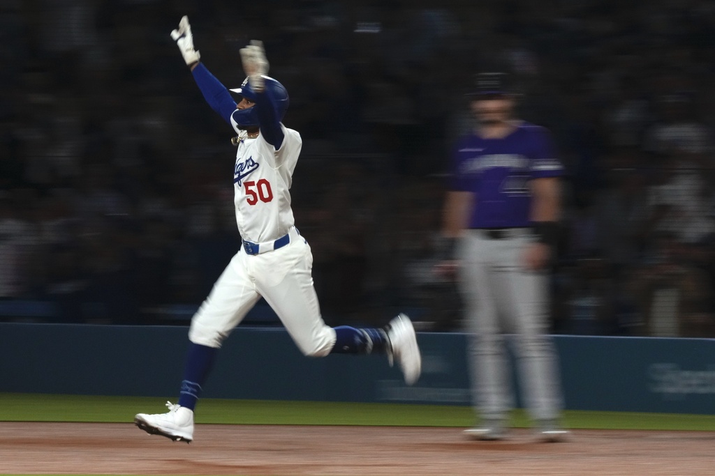 Los Angeles Dodgers' Mookie Betts, left, celebrates after hitting a two-run home run as Colorado Rockies first baseman Michael Toglia watches during the third inning of a baseball game Tuesday, Sept. 9, 2025, in Los Angeles. (AP Photo/Mark J. Terrill)