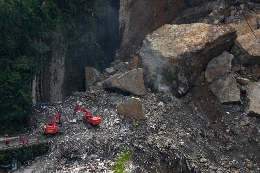 Rescuers use heavy duty machinery to clear rubble as they search for trapped victims at the scene of a landslide in Pengshui County in southwestern China's Chongqing on Sunday, July 19, 2026. (AP Photo/Andy Wong)