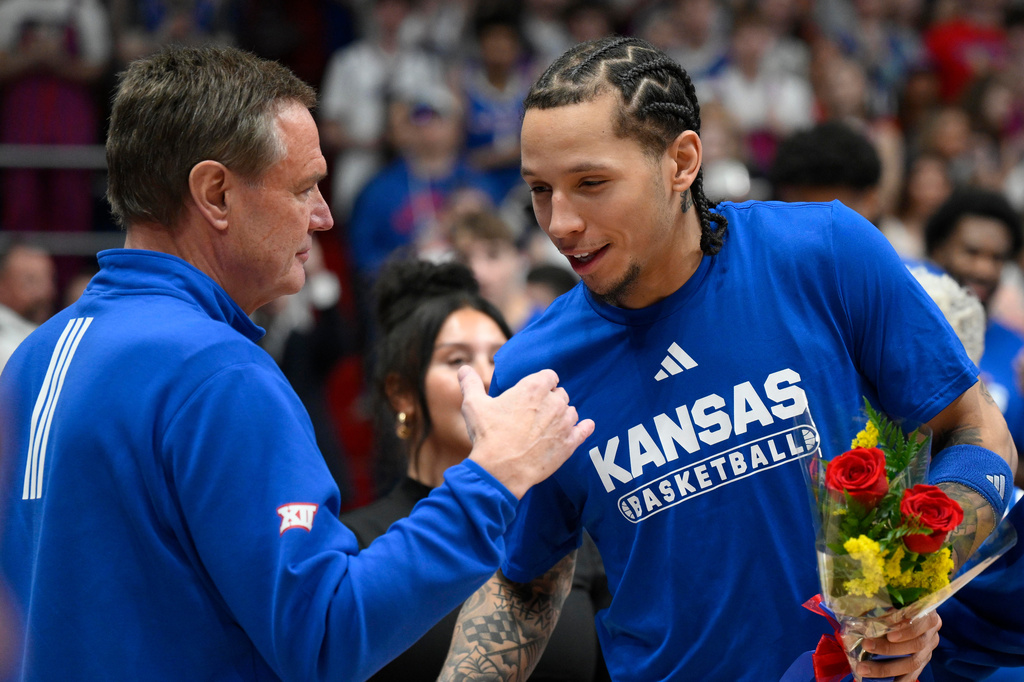 FILE - Kansas head coach Bill Self, left, give Kansas guard Tre White, right, a hug during Senior Day events before the first half of an NCAA college basketball game against Kansas State in Lawrence, Kan., March 7, 2026. (AP Photo/Reed Hoffmann, File)