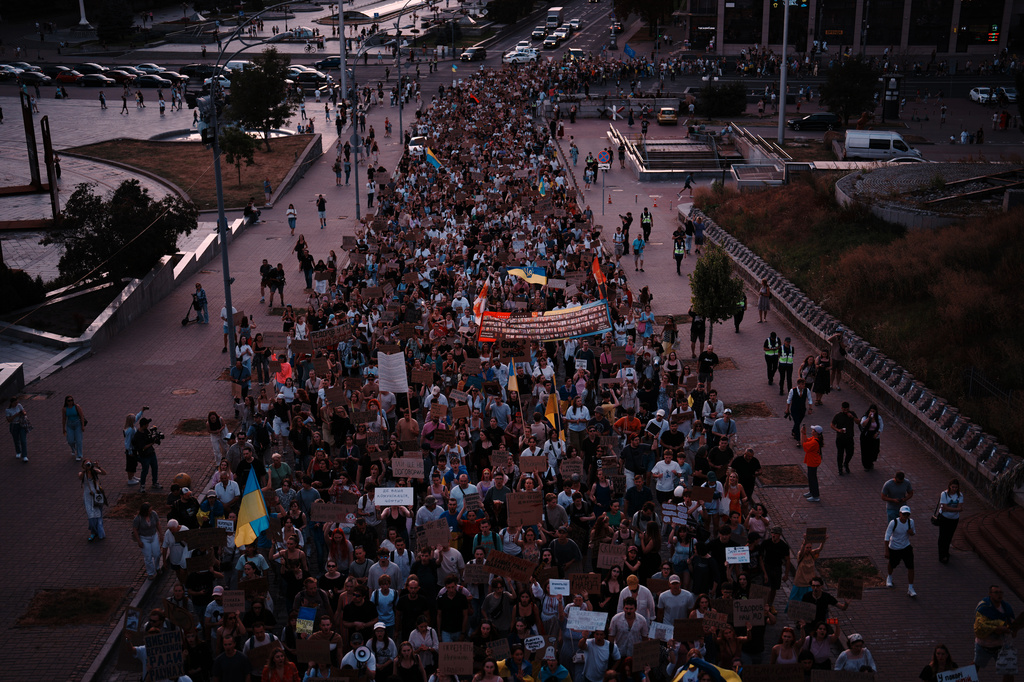 People march during a rally to protest the dismissal of Mykhailo Fedorov as Ukraine's Defense Minister in Kyiv, late Sunday, Aug. 16, 2026. (AP Photo/Francisco Seco)