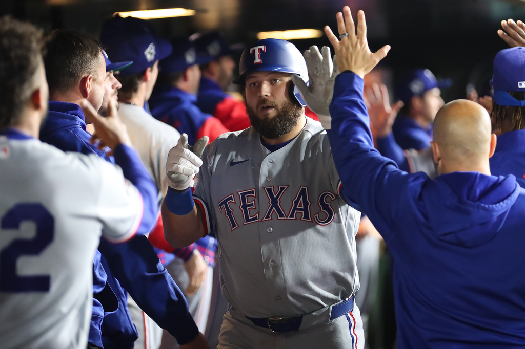 Texas Rangers' Jake Burger, middle, celebrates with teammates after hitting a three-run home run during the eighth inning of a baseball game against the Athletics, Wednesday, April 15, 2026, in West Sacramento, Calif. (AP Photo/Scott Marshall)