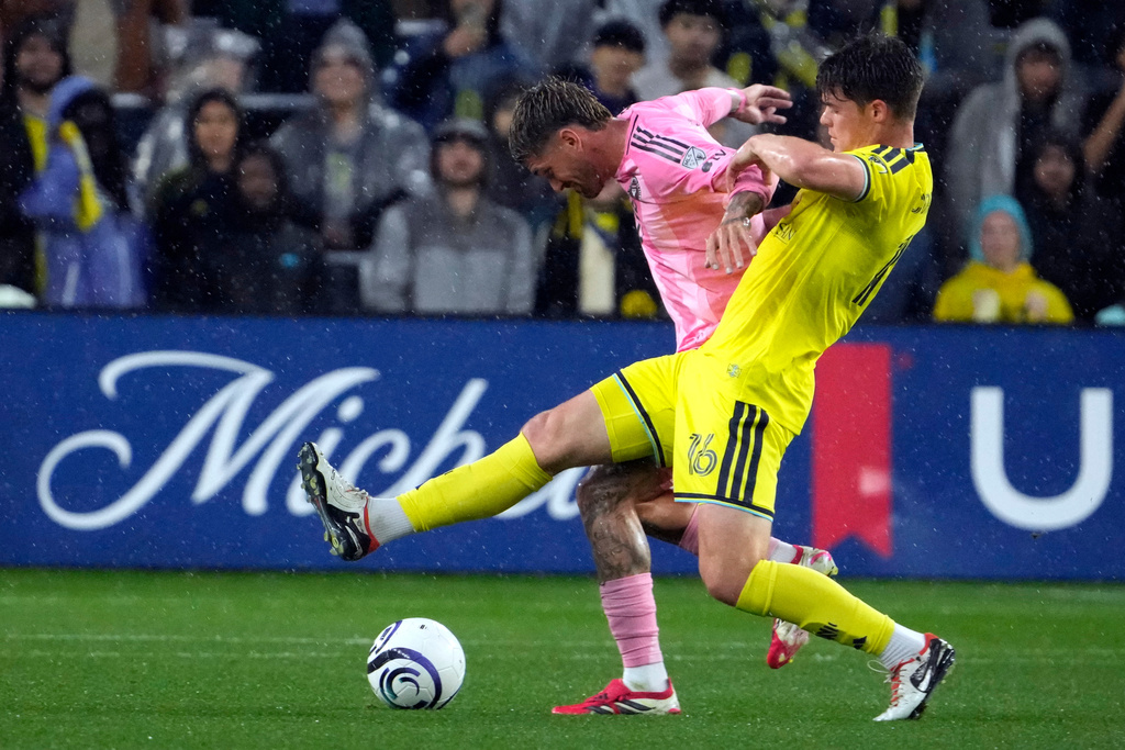 Inter Miami's Rodrigo de Paul, left, and Nashville SC's Matthew Corcoran, right, battler for the ball in the first half of a CONCACAF Champions Cup Round of 16 soccer match Wednesday, March 11, 2026, in Nashville, Tenn. (AP Photo/Mark Humphrey)