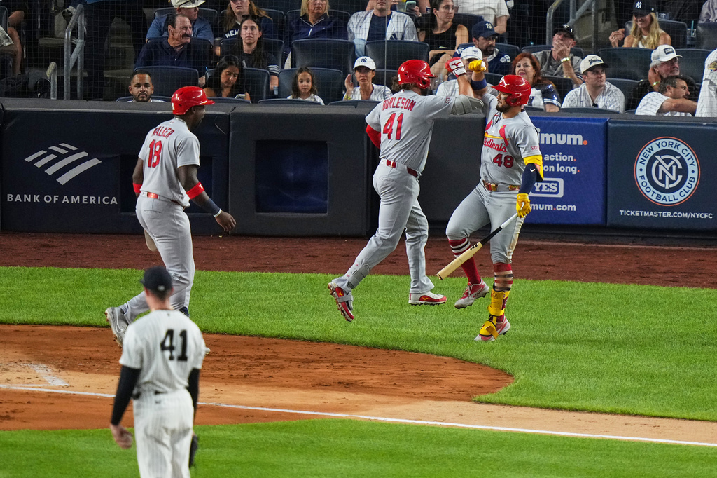 New York Yankees pitcher Tim Hill (41) watches as St. Louis Cardinals' Alec Burleson (41) celebrates with teammates Iván Herrera (48) and Jordan Walker (18) after hitting a two-run home run during the fourth inning of a baseball game Monday, Aug. 3, 2026, in New York. (AP Photo/Frank Franklin II)