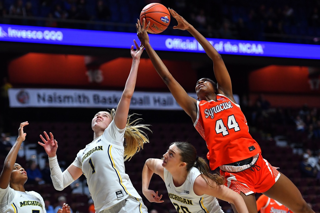 Michigan guard Olivia Olson (1) and forward Alyssa Crockett, center, vie for control of the ball with Syracuse center Uche Izoje (44) in the first half of an NCAA college basketball game, Sunday, Nov. 23, 2025, in Uncasville, Conn. (AP Photo/Steven Senne)
