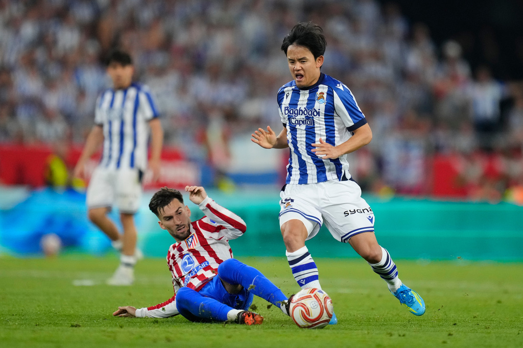 Real Sociedad's Takefusa Kubo, right, and Atletico Madrid's Alex Baena challenge for the ball during the Copa del Rey final soccer match between Atletico Madrid and Real Sociedad in Seville, Spain, Saturday, April. 18, 2026. (AP Photo/Jose Breton)
