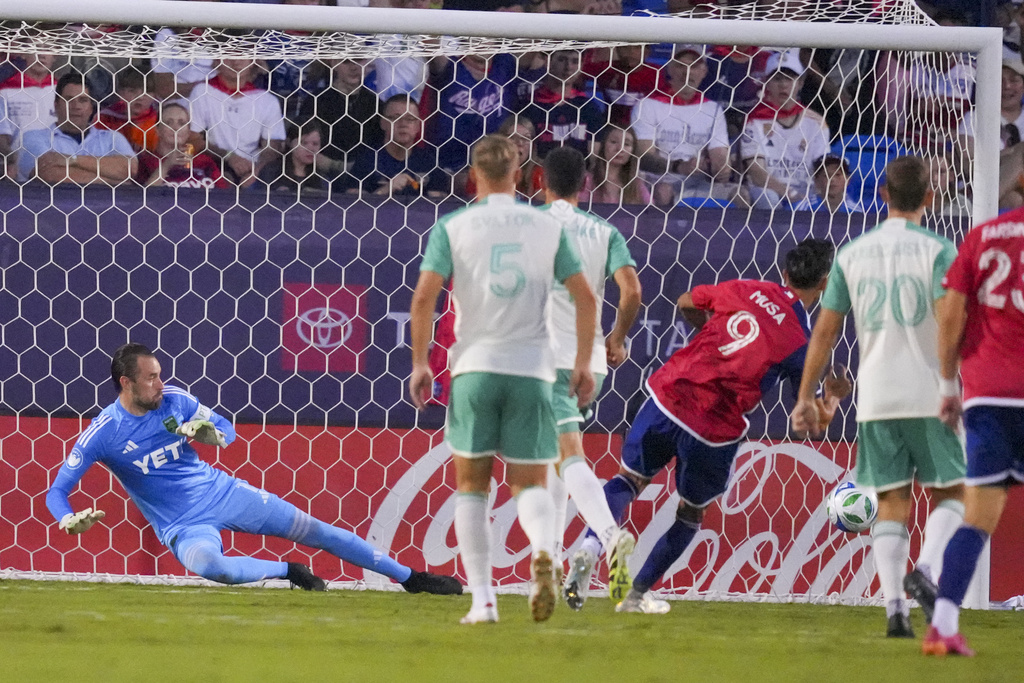 FC Dallas forward Petar Musa (9) scores a goal on Austin FC goalkeeper Brad Stuver during the first half of an MLS soccer match Saturday, Sept. 13, 2025, in Frisco, Texas. (AP Photo/Julio Cortez)