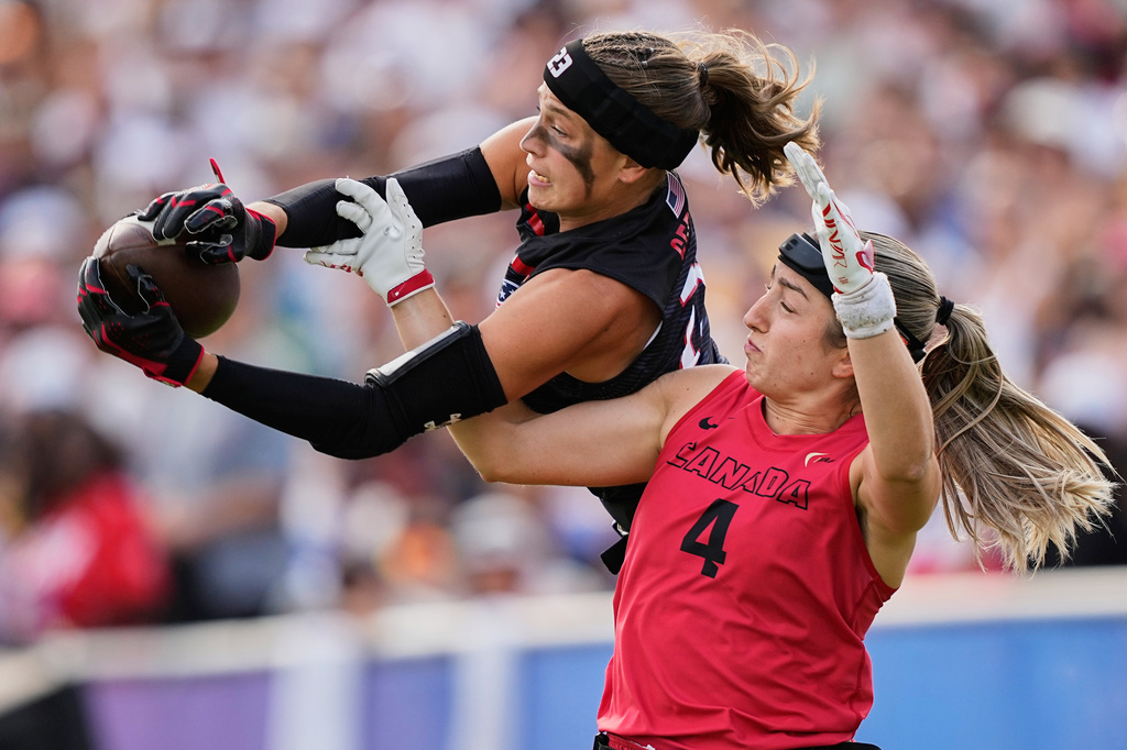 FILE - Isabella Geraci of the United States and Rosalie Landry of Canada challenge for the ball during the Flag Football World Championship women's final game between Canada and USA in Duesseldorf, Germany, Sunday, Aug. 16, 2026. (AP Photo/Martin Meissner, File)