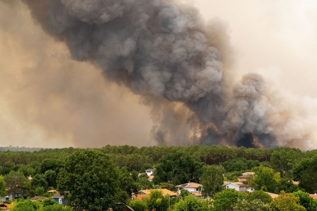 Smoke rises over wildfires in the Lège-Cap-Ferret region, western France, Thursday, July 23, 2026. (AP Photo/Caroline Blumberg)