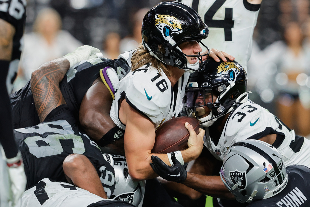 Jacksonville Jaguars quarterback Trevor Lawrence (16) scores a touchdown against the Las Vegas Raiders during overtime of an NFL football game, Sunday, Nov. 2, 2025, in Las Vegas. (AP Photo/Steve Marcus)