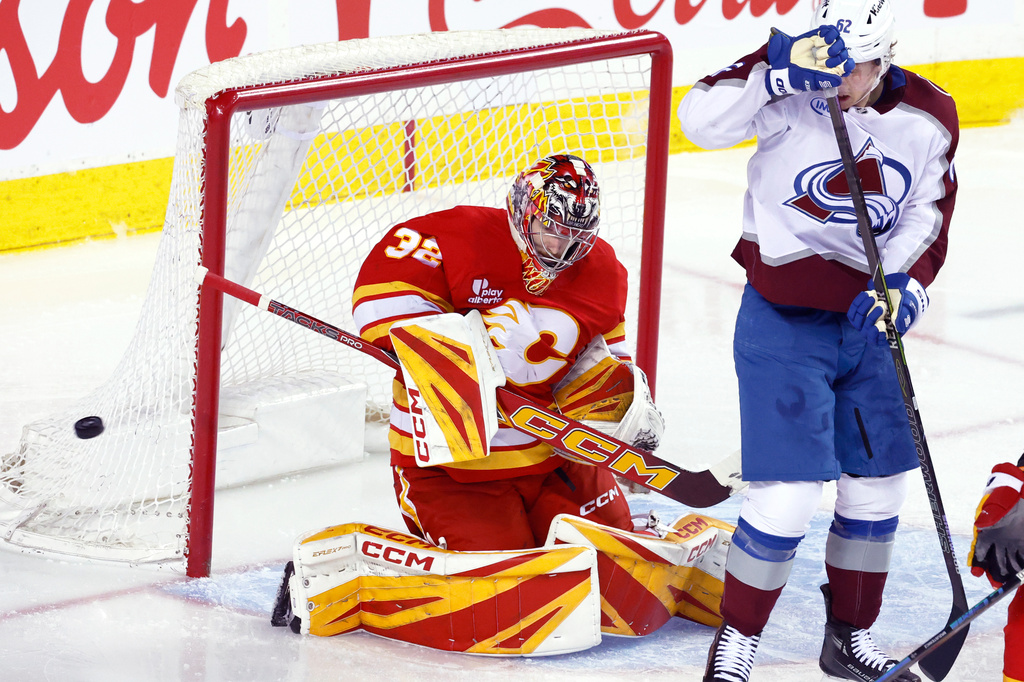 Colorado Avalanche's Artturi Lehkonen, right, looks for a rebound after Calgary Flames goalie Dustin Wolf makes a save during the second period of an NHL hockey game in Calgary, Tuesday, April 14, 2026. (Larry MacDougal/The Canadian Press via AP)