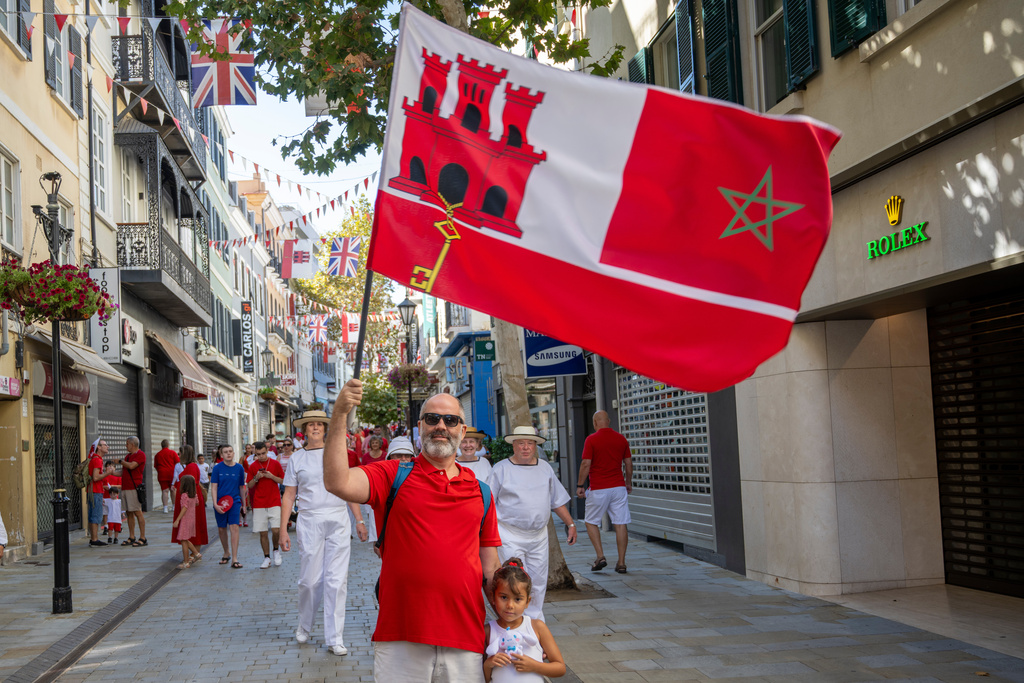 A man holds a Gibraltar flag during National Day celebrations in the contested territory of Gibraltar on Wednesday Sept. 10, 2025. (AP Photo/Marcos Moreno)
