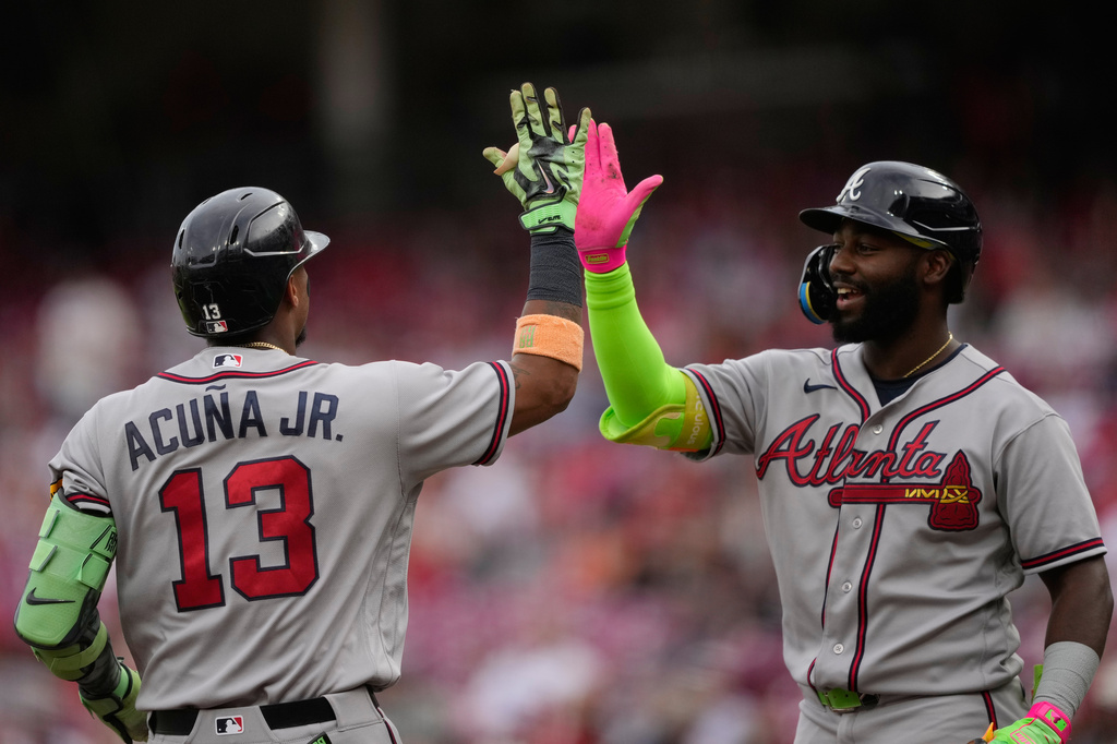 Atlanta Braves' Ronald Acuña Jr. left, celebrates after hitting a solo home run with Michael Harris II, right, during the first inning of a baseball game against the Cincinnati Reds in Cincinnati, Friday, May 29, 2026. (AP Photo/Carolyn Kaster)