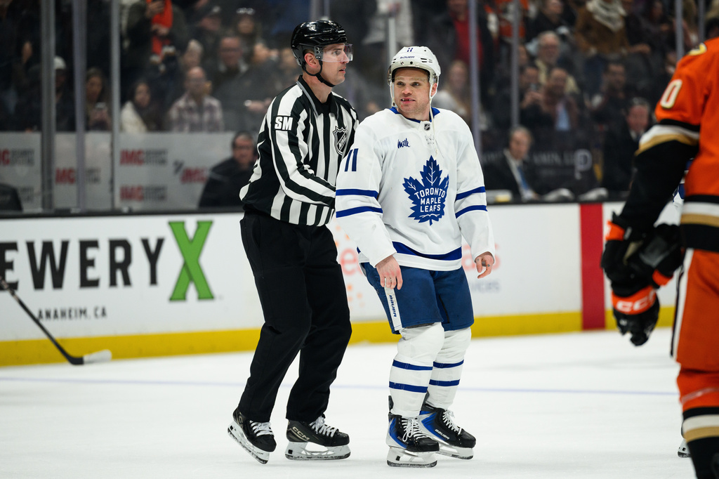 Toronto Maple Leafs center Max Domi (11) is escorted out of an NHL hockey game during the second period against the Anaheim Ducks, Monday, March 30, 2026, in Anaheim, Calif. (AP Photo/William Liang)