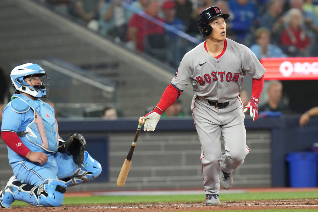Boston Red Sox's Masataka Yoshida (7) hits a solo home run in front of Toronto Blue Jays catcher Alejandro Kirk (30) during fifth inning MLB baseball action in Toronto on Wednesday, Sept. 24, 2025. (Chris Young/The Canadian Press via AP)