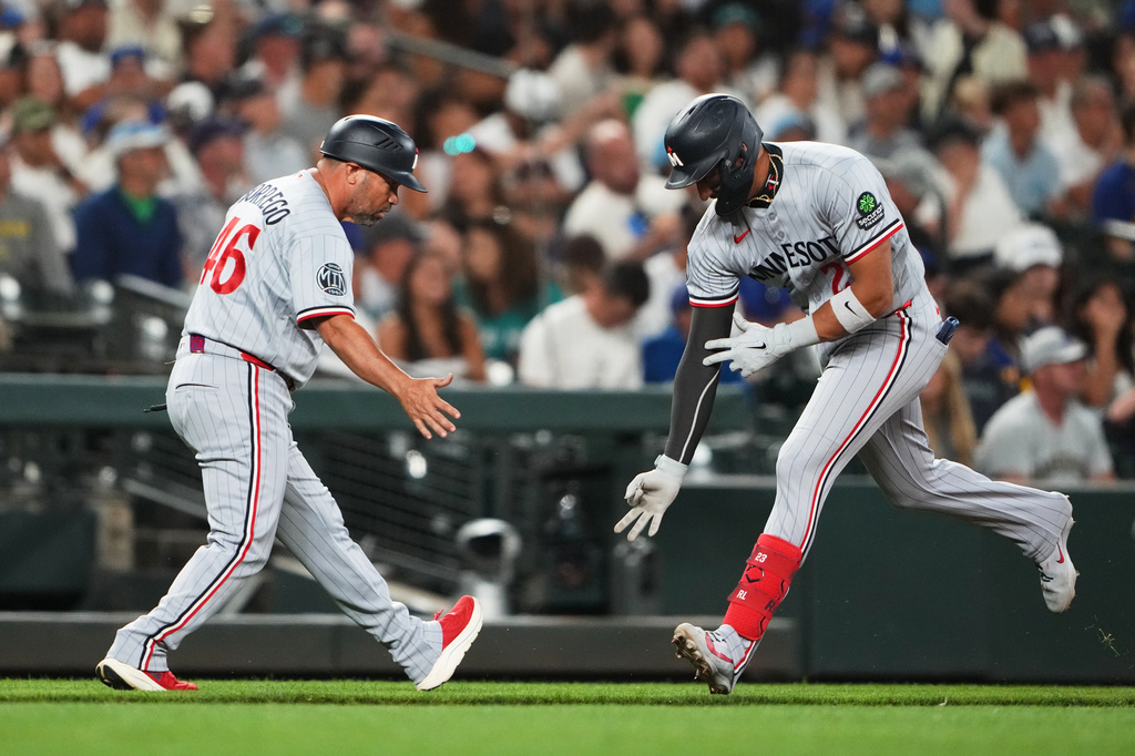 Minnesota Twins' Royce Lewis, right, celebrates with third base coach Ramon Borrego (46) after hitting a solo home run against the Seattle Mariners during the seventh inning of a baseball game, Friday, July 31, 2026, in Seattle. (AP Photo/Lindsey Wasson)