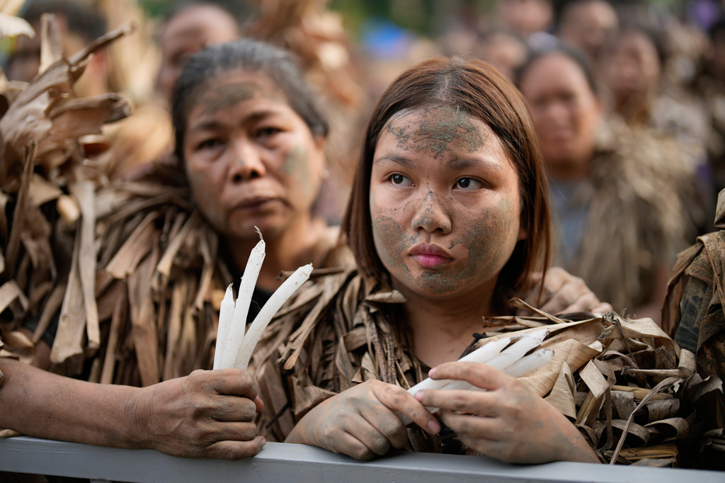 A Catholic devotee covered in mud and dried banana leaves participates in the mud people festival on the feast day of Saint John the Baptist at Bibiclat, Nueva Ecija province, northern Philippines on Wednesday, June 24, 2026. (AP Photo/Aaron Favila)