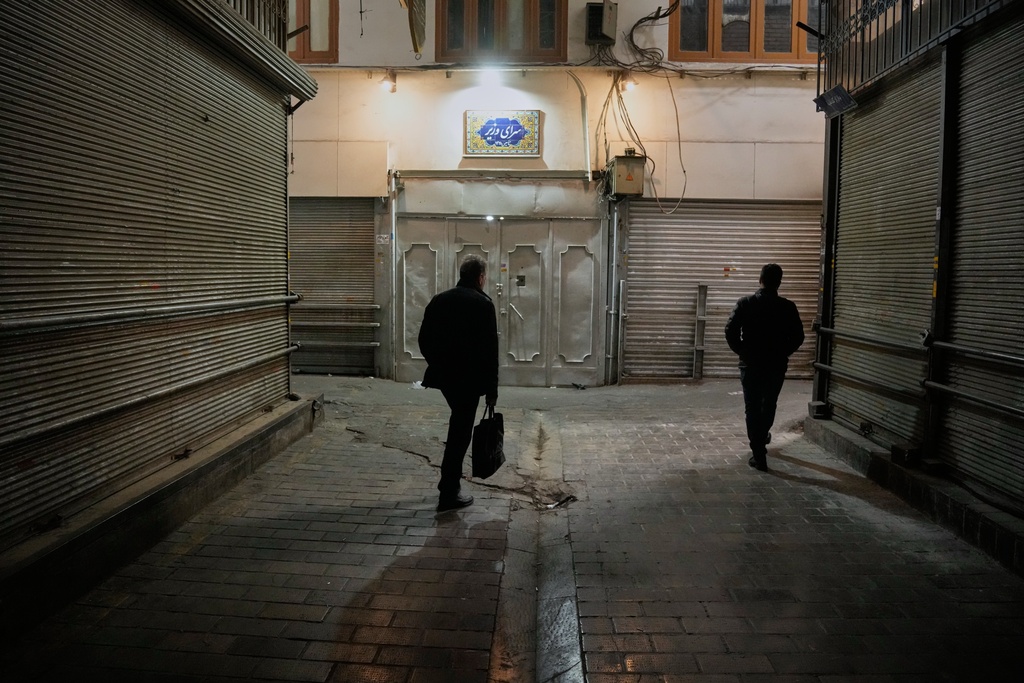People walk past closed shops at the nearly empty traditional main bazaar in Tehran, Iran, Tuesday, March 10, 2026. (AP Photo/Vahid Salemi)