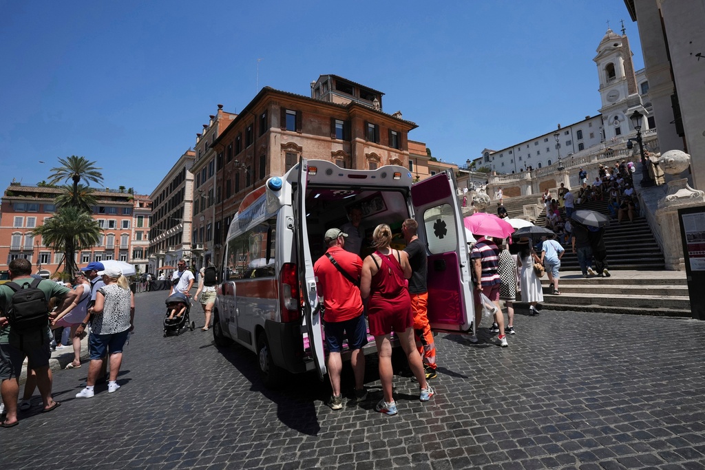 FILE - Paramedics provide aid to tourists and residents with an ambulance, next to the historical Spanish Steps, in Rome, Italy, July 1, 2025. (AP Photo/Andrew Medichini, File)