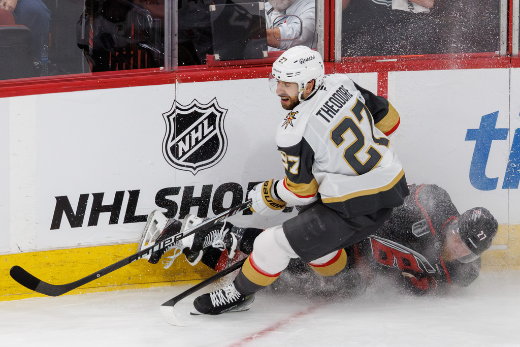 Vegas Golden Knights' Shea Theodore, left, and Carolina Hurricanes' Nikolaj Ehlers, right, collide during the second period in Game 1 of the NHL hockey Stanley Cup Final series in Raleigh, N.C., Tuesday, June 2, 2026. (AP Photo/Ben McKeown)