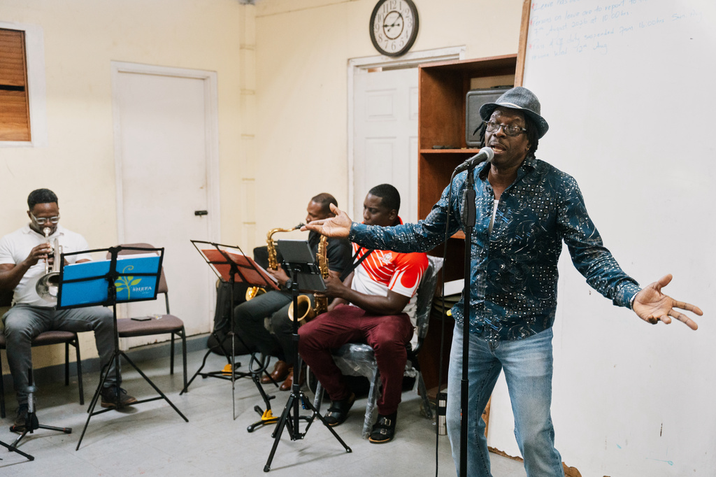 Father Gerard Paul, who can no longer officiate masses, funerals, weddings or baptisms after repeatedly criticizing the church and clergy, rehearses with Royal Grenada Police Force Band in St. George, Grenada, Thursday, Aug. 6, 2026. (AP Photo/Floyd Robinson)