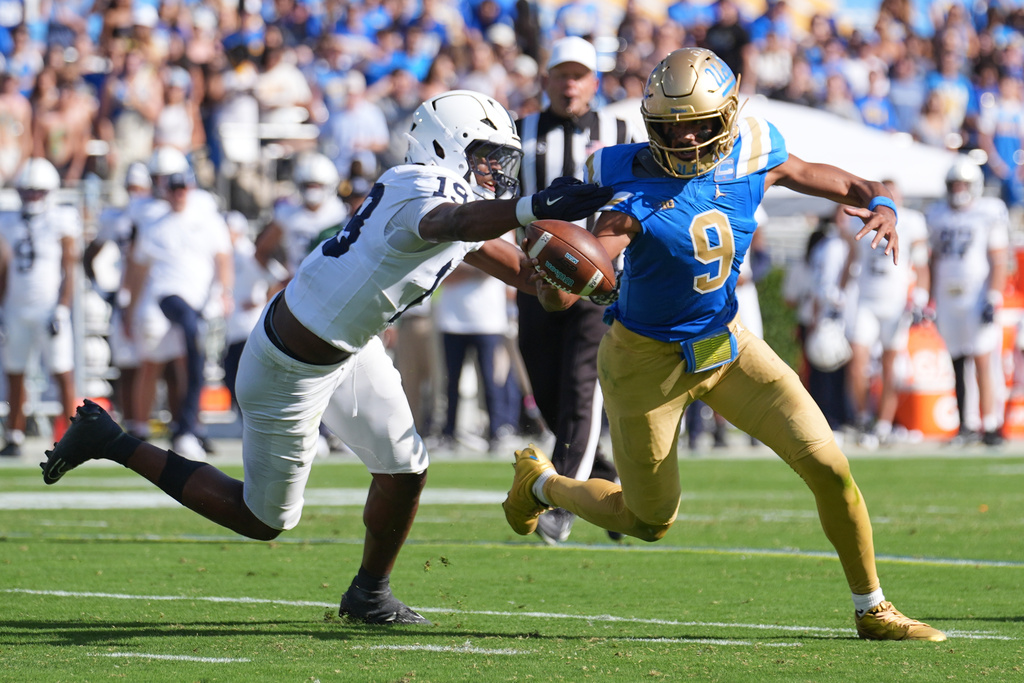 UCLA quarterback Nico Iamaleava (9) runs past Penn State defensive end Chaz Coleman (19) during the second half of an NCAA college football game Saturday, Oct. 4, 2025, in Pasadena, Calif. (AP Photo/Marcio Jose Sanchez)