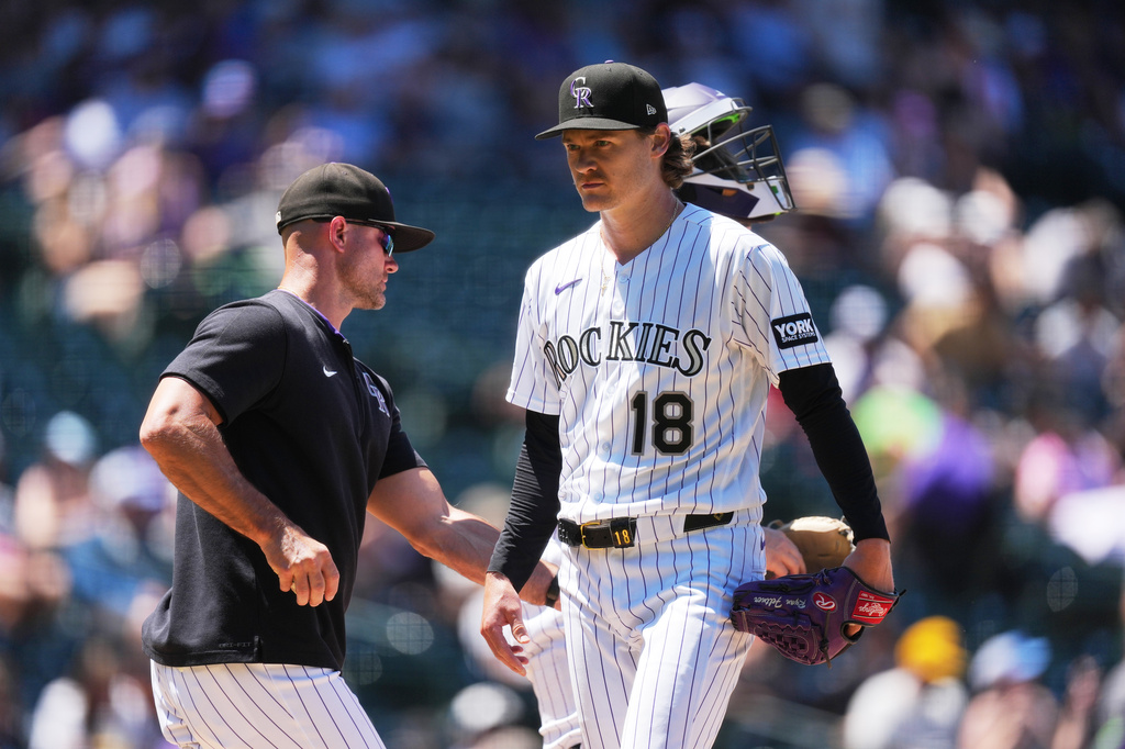 Colorado Rockies manager Warren Schaeffer, left, takes the ball from starting pitcher Ryan Feltner (18) as Feltner is pulled from the mound after issuing back-to-back walks in the third inning of a baseball game against the Cincinnati Reds, Sunday, July 19, 2026, in Denver. (AP Photo/David Zalubowski)