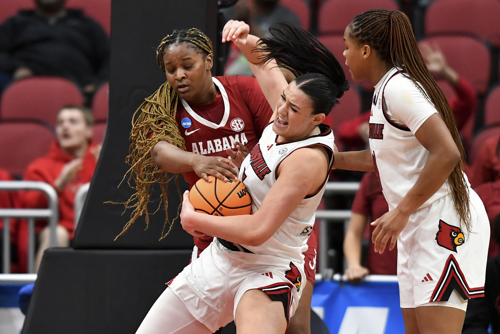 Louisville forward Elif Istanbulluoglu, center, battles Alabama forward Essence Cody, left, for possession of the ball during the second half in the second round of the NCAA college basketball tournament, Monday, March 23, 2026, in Louisville, Ky. (AP Photo/Timothy D. Easley)
