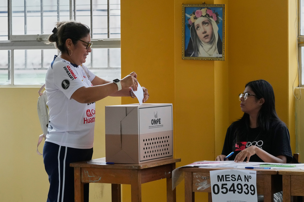 A woman votes as polling resumes at a station affected by delays and logistical problems during general elections in Lima, Peru, Monday, April 13, 2026. (AP Photo/Martin Mejia)