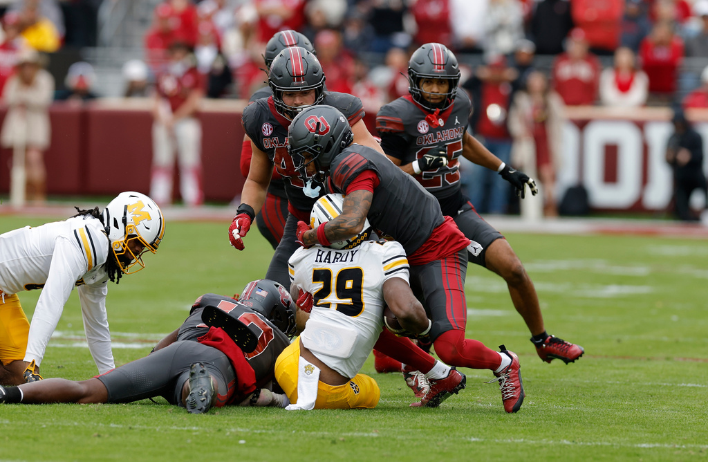 Oklahoma defensive back Courtland Guillory (4) stops Missouri running back Ahmad Hardy (29) during the first half of an NCAA college football game Saturday, Nov. 22, 2025, in Norman, Okla. (AP Photo/Alonzo Adams)