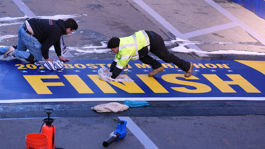 Workers scrub the finish line clean prior to the Boston Marathon, Monday, April 20, 2026, in Boston. (AP Photo/Charles Krupa)