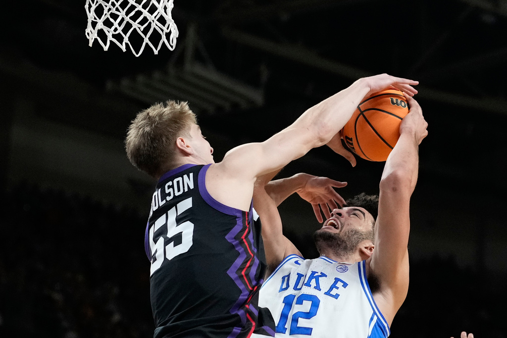 Duke forward Cameron Boozer (12) looks to shoot against TCU guard Tanner Toolson (55) during the first half in the second round of the NCAA college basketball tournament, Saturday, March 21, 2026, in Greenville, S.C. (AP Photo/Brynn Anderson)